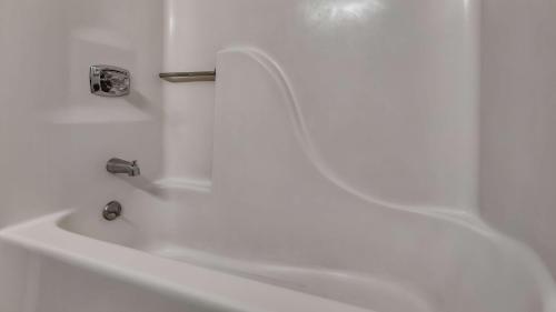 a white bath tub with a faucet in a bathroom at Best Western Lapeer Inn in Lapeer