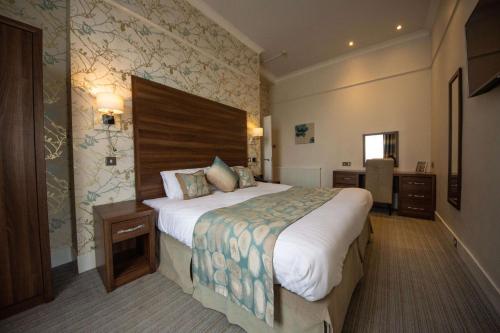 a hotel room with a large bed in it at Best Western York House Hotel in Eastbourne