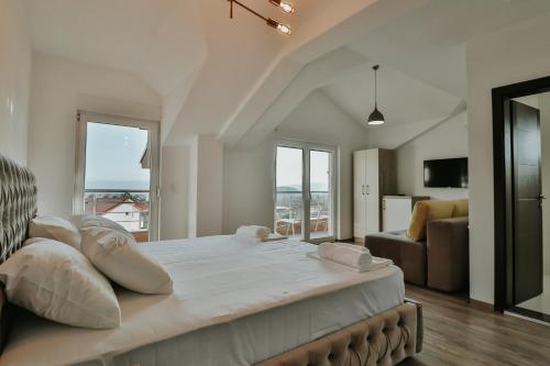 um grande quarto branco com uma cama grande e um sofá em Villa TEMA em Ohrid