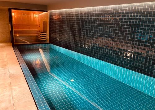 a large swimming pool with blue tiles in a bathroom at Pousada Porto Rua das Flores in Porto