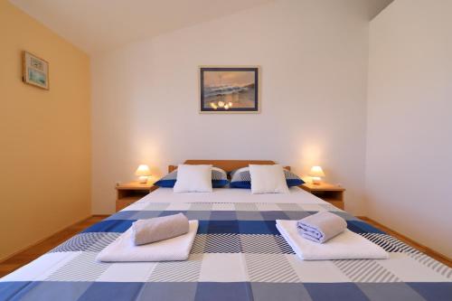 a bedroom with a blue and white bed with two pillows at Vanda Land penthouse in Zadar