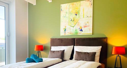 een slaapkamer met een bed met 2 lampen en een schilderij bij BESOTEL Mettmann in Mettmann