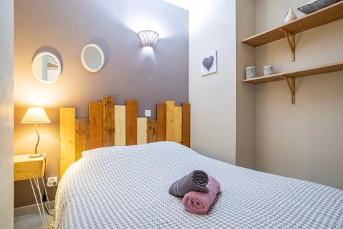 a bedroom with a bed with a pink towel on it at Gite Le Caveau Sélestat - 30min EuropaPark in Sélestat