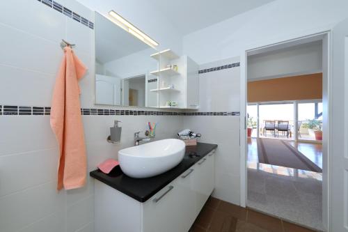 a white bathroom with a sink and a mirror at Vanda Land penthouse in Zadar