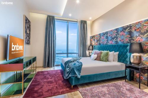 Cette chambre comprend un lit et une grande fenêtre. dans l'établissement bnbmehomes - Lux 2B Apt - Dubai Canal Water View - 4406, à Dubaï