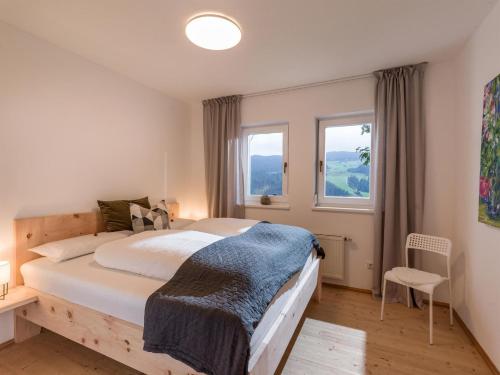 una camera con un grande letto e due finestre di Blick auf's Schloss a Itter