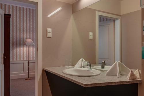 a bathroom with a sink and a mirror at Hotel Praga 1885 in Prague