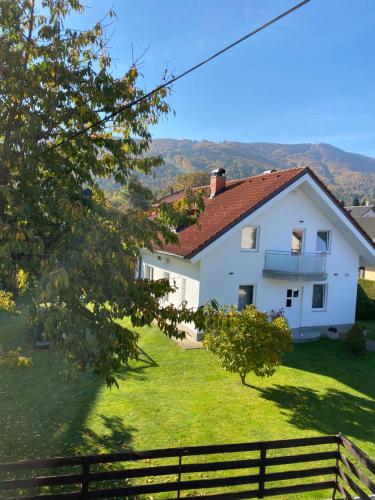 una casa blanca en un patio verde con una valla en House Marin - whole house en Maribor