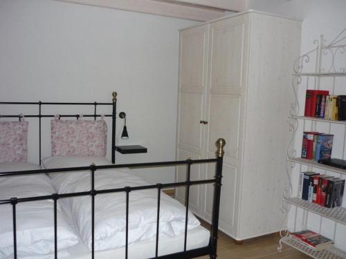 ein Schlafzimmer mit einem Bett und einem Bücherregal mit Büchern in der Unterkunft Little Rose Cottage in Börm