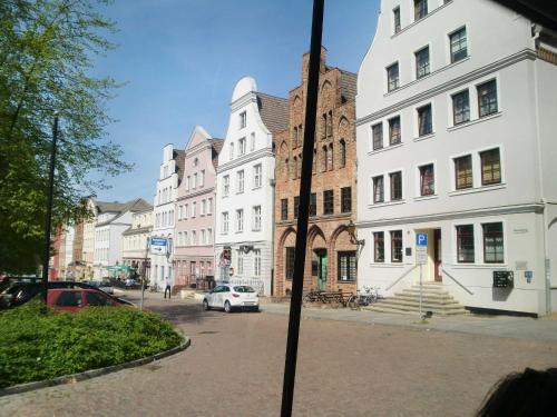 een raam met uitzicht op een straat met gebouwen bij Ferienwohnungen Am Schwanenteich in Rostock