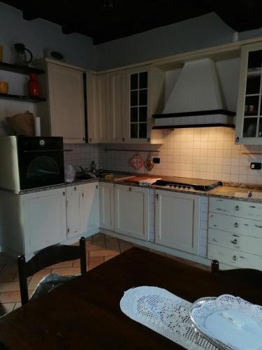 a kitchen with white cabinets and a stove top oven at Appartamento in storica Cascina Lombarda Cusago Rho-Fiera-San-Siro in Cusago