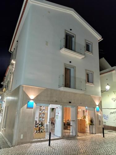 a white building with blue lights in front of it at Nazaré Sweet Dreams in Nazaré