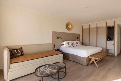 a hotel room with two beds and a table at Hotel L'Acquale in Calvi