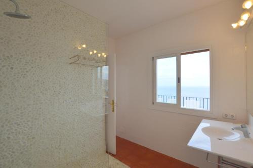 ein Badezimmer mit Dusche und Waschbecken und einem Fenster in der Unterkunft Alconasser 10 - Amazing Seaviews between Deia & Soller in Port de Sóller
