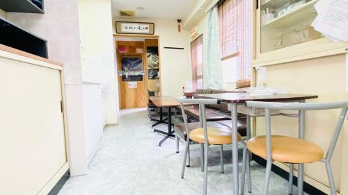 
a kitchen area with a table and chairs at GUEST HOUSE B's FiveⅡ in Osaka
