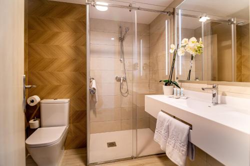 y baño con ducha, aseo y lavamanos. en Hotel Rosamar REOPENING 15 of June 2024, en Benidorm
