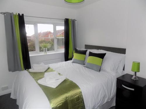a bedroom with a large white bed with green curtains at Hive Close in Stockton-on-Tees