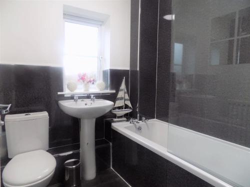蒂斯河畔斯托克頓的住宿－Hive Close，浴室配有盥洗盆、卫生间和浴缸。