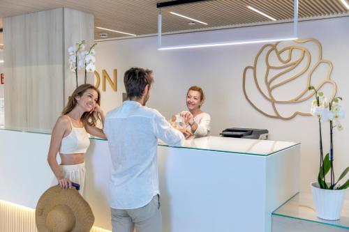 a man holding a baby at a counter in a store at Hotel Rosamar in Benidorm