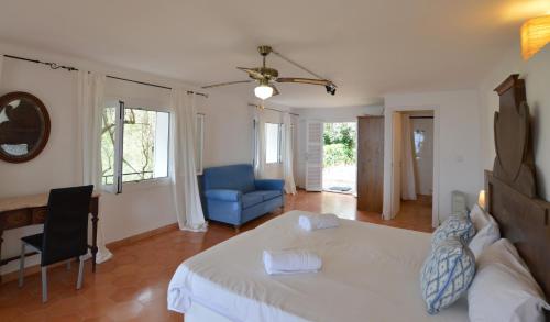 a bedroom with a white bed and a blue chair at Alconasser 2 - Amazing Seaviews between Deia & Soller in Sóller