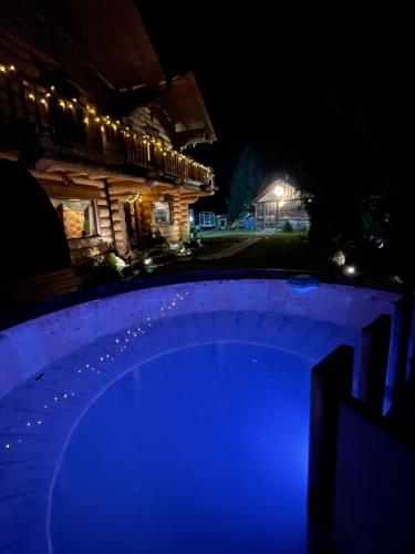 a blue pool in front of a house at night at The Mountain's Sea Chalet in Colibiţa