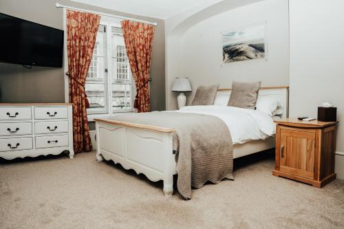 ディバイザスにあるThe Peppermill Town house Hotel & Restaurantの白いベッドと窓のある寝室