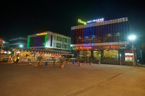 un grupo de edificios por la noche con luces en Hotel G-Square - Shirdi, en Shirdi