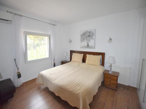 um quarto branco com uma cama e uma janela em Casa Feliz Javea em Balcon del Mar