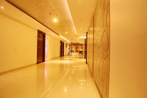 an empty hallway in a building with ailed floor at Hotel G-Square - Shirdi in Shirdi