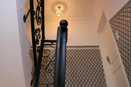 a staircase with a wrought iron rail and a light at Tiwaline Tarsime App E in Sidi Ifni