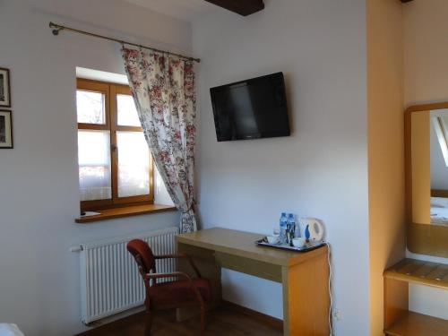 Zimmer mit einem Schreibtisch und einem TV an der Wand in der Unterkunft Giszowiec Pokoje gościnne Przyjazna 9 in Kattowitz