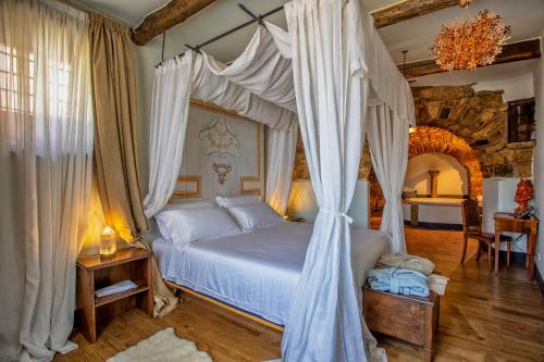 sypialnia z łóżkiem z baldachimem w obiekcie Dimora storica Giorni resort & spa w mieście Pignola