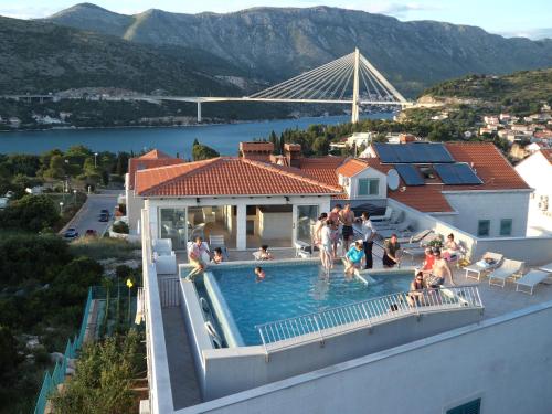a group of people in a swimming pool with a bridge at Villa Antea Apartments in Dubrovnik