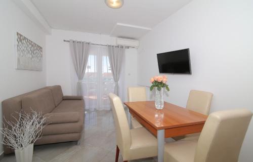 a dining room with a table and a couch at Villa Antea Apartments with Free Parking in Dubrovnik