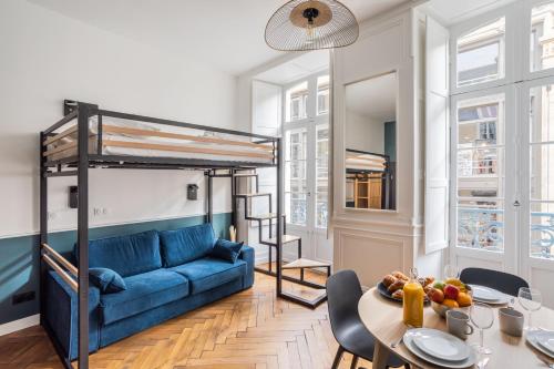 - un salon avec un canapé bleu et des lits superposés dans l'établissement GLOIRE - Petit cocon dans le cœur historique de Rennes, à Rennes