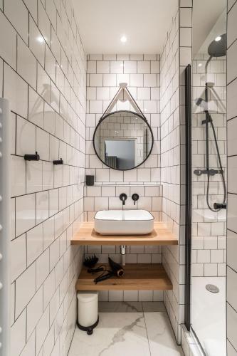 une salle de bain avec un lavabo et un miroir dans l'établissement GLOIRE - Petit cocon dans le cœur historique de Rennes, à Rennes