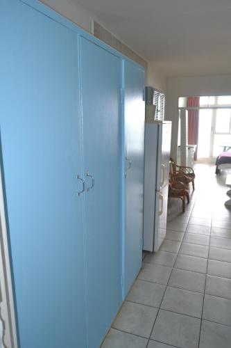 a blue door in a room with a kitchen at Driftsands Sea View Flats in Uvongo Beach