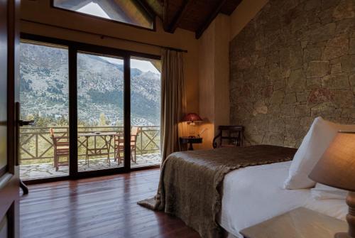 a bedroom with a bed and a large window at Parnassus Dreamwood Chalet in Eptalofos