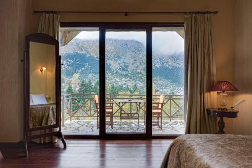 a bedroom with a door open to a balcony at Parnassus Dreamwood Chalet in Eptalofos