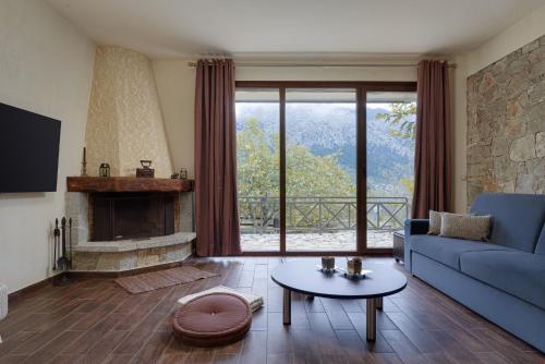 a living room with a blue couch and a fireplace at Parnassus Dreamwood Chalet in Eptalofos