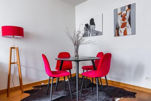 une salle à manger avec des chaises rouges et une table dans l'établissement L'ECHAPPEE BELLE - T2 au cœur de Nantes, à Nantes