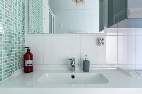 - un lavabo avec une bouteille de savon et un miroir dans l'établissement L'ECHAPPEE BELLE - T2 au cœur de Nantes, à Nantes