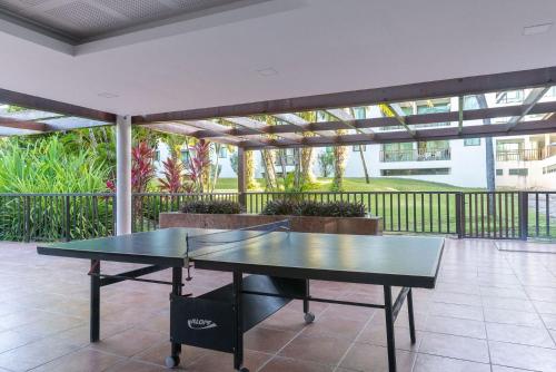 a ping pong table sitting on a patio at Flat ou Bangalo Luxo Beach Class Beira Mar Muro Alto in Porto De Galinhas