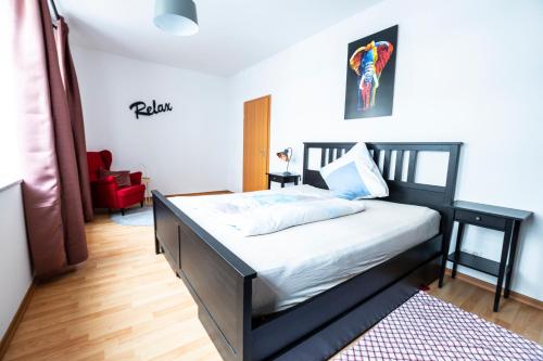 a bedroom with a bed and a red chair at Mein Brühl-Stadtmitte, fußläufig zur TU und Bibliothek in Chemnitz