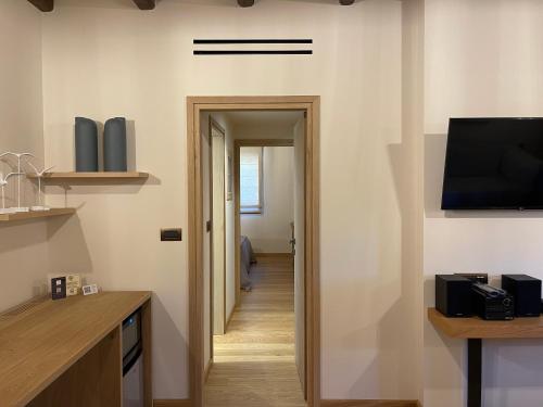 a hallway leading to a kitchen with a television and a hallway sidx sidx at Mystras Grand Palace Resort & Spa in Mystras