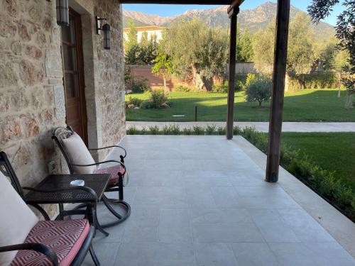 a patio with chairs and a view of a yard at Mystras Grand Palace Resort & Spa in Mystras