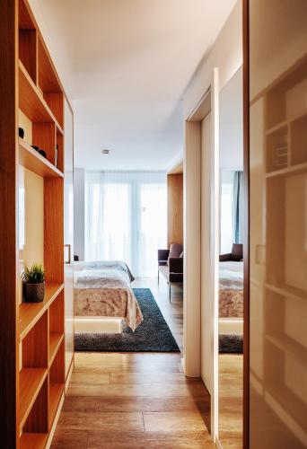 a bedroom with a bed and a room with a mirror at Seevital Hotel & SPA - Ihr 4 Sterne Superior Hideaway direkt am See in Langenargen