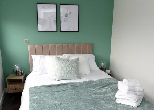 a bedroom with a large bed with blue walls at Trendy city centre apartment with free parking in Cardiff