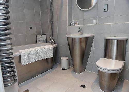 La salle de bains est pourvue d'une baignoire, d'un lavabo et de toilettes. dans l'établissement Trendy city centre apartment with free parking, à Cardiff