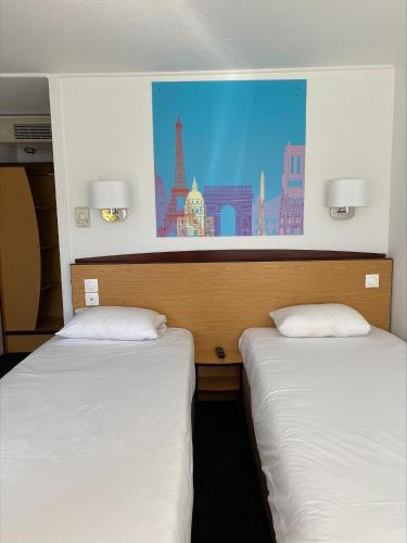 two beds in a room with a painting on the wall at Kyriad Direct Marseille Est La Valentine in La Penne-sur-Huveaune